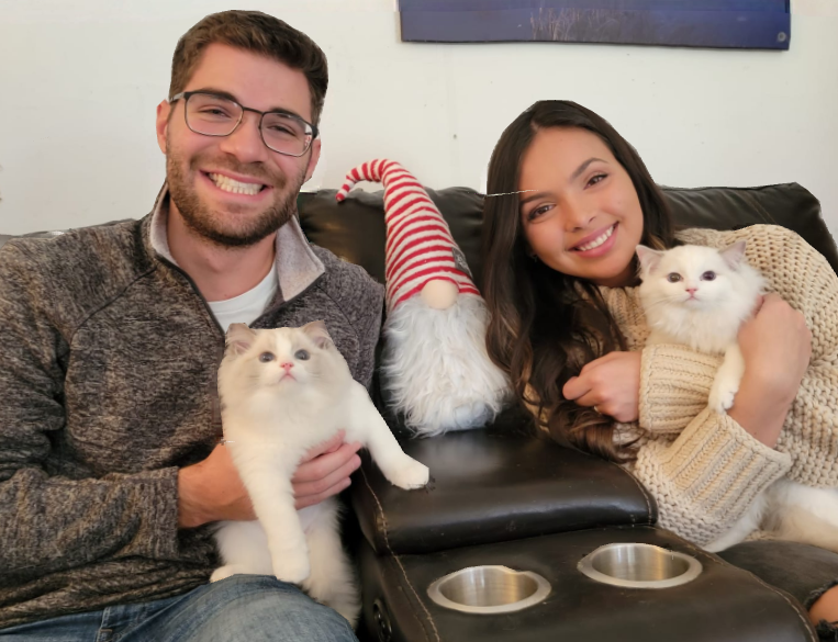 A couple on the couch with two Blossom Ragdolls